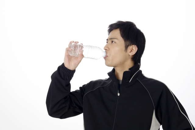 ペットボトルの水を飲む男性